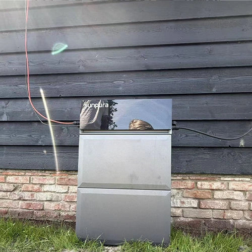 Sunpura battery storage installed outdoors beside a house wall